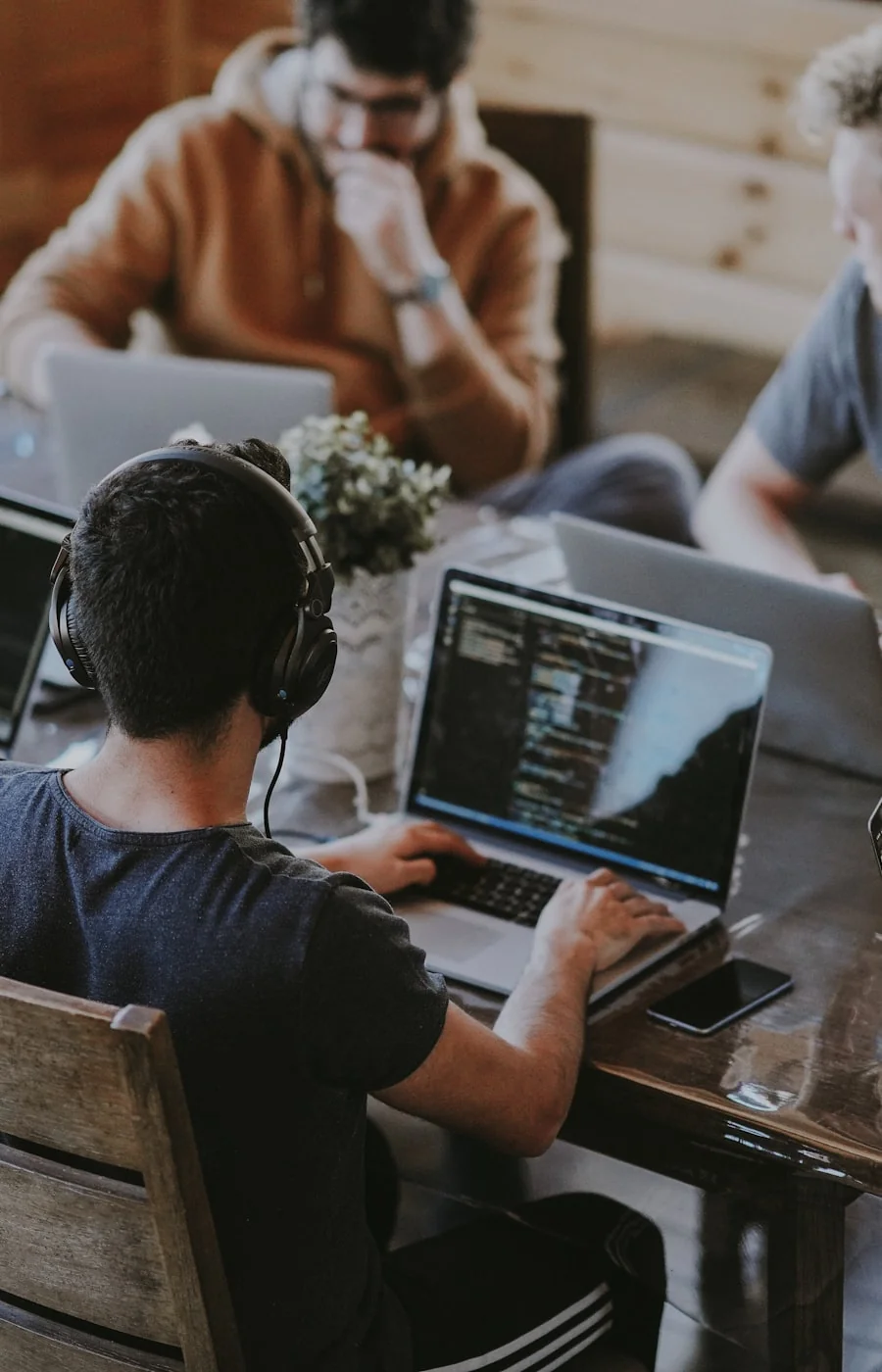 Zespół pracujący na laptopach przy wspólnym stole